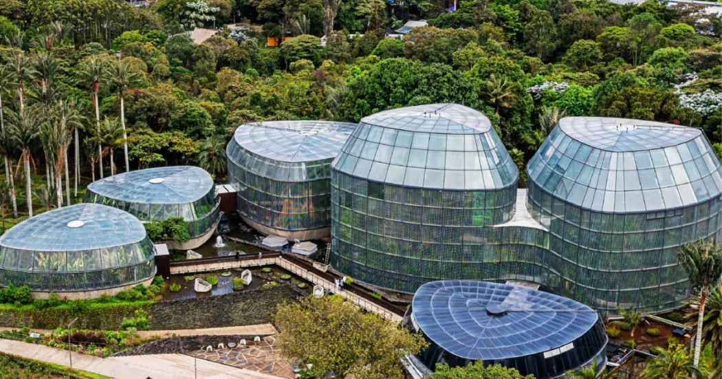 Vista aérea del Tropicario del Jardín Botánico de Bogotá con módulos de vidrio rodeados de vegetación abundante