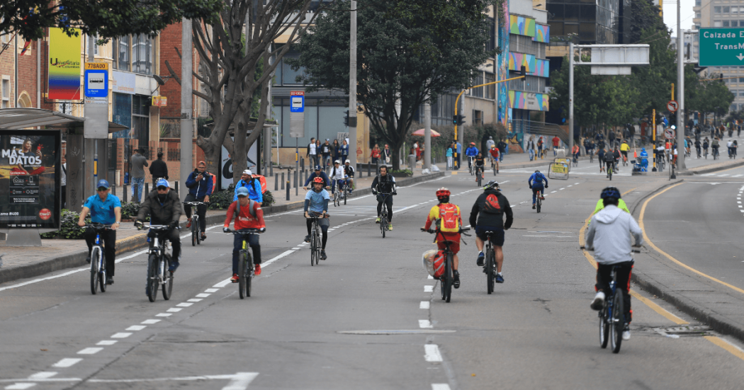 Ciclistas recorren una avenida de Bogotá durante la Ciclovía, utilizando los carriles habilitados para bicicletas.