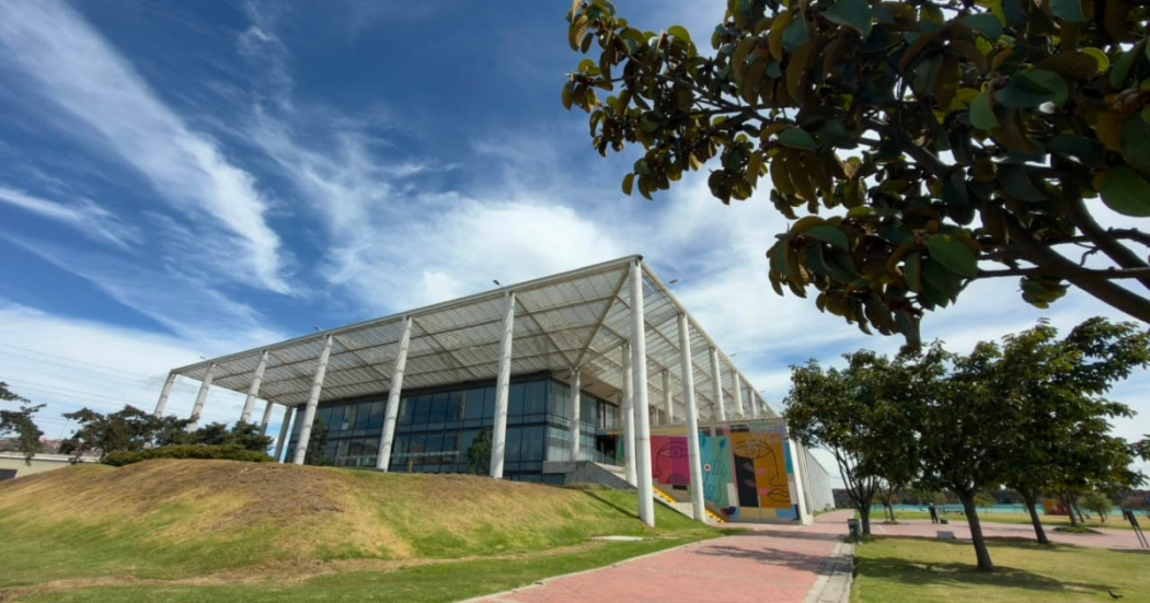 Foto que muestra un edificio con techo blanco y paredes en cristal 