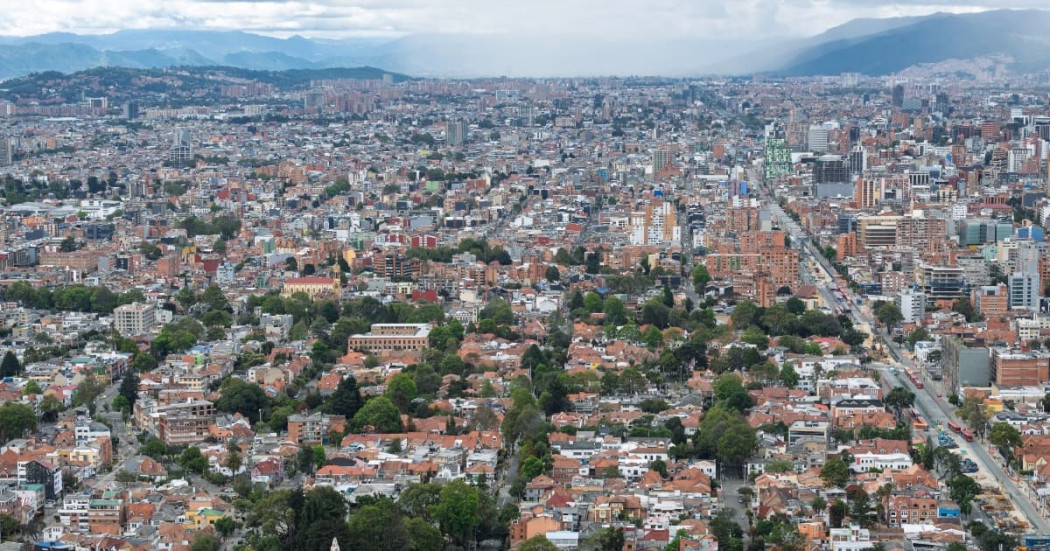 Vista panorámica de Bogotá con amplia zona residencial, edificaciones densas, avenidas principales, cerros orientales y cielo nublado asociada al pronóstico del clima.
