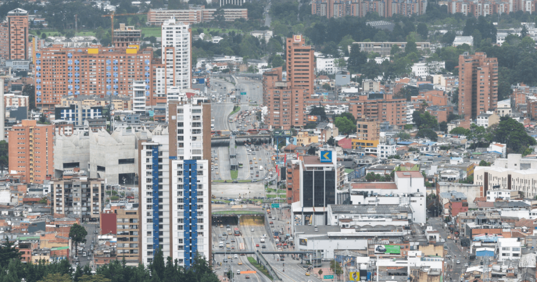 Vista panorámica de Bogotá con edificios residenciales y comerciales, corredores viales de alto tráfico, torres de gran altura y amplia concentración urbana.