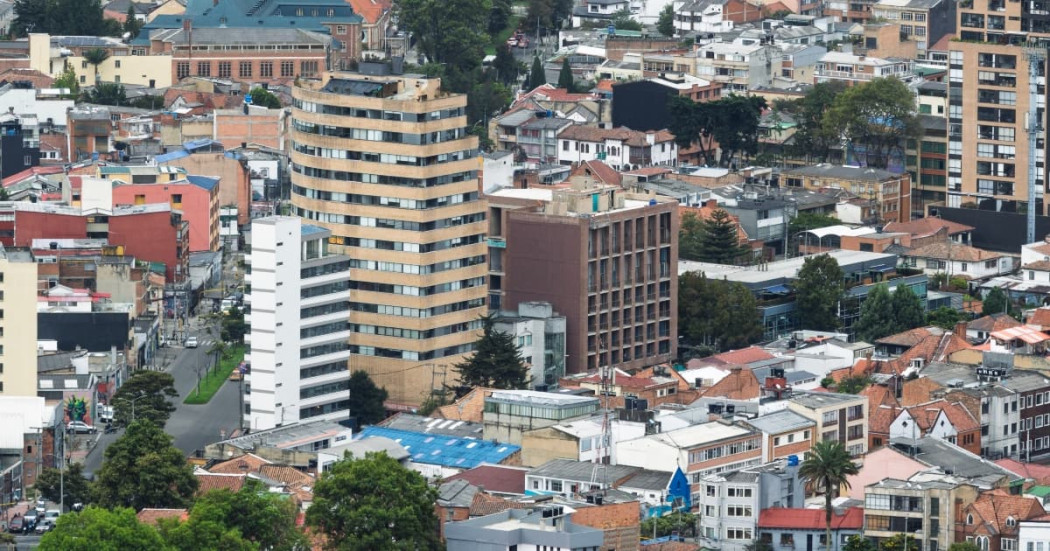 Vista aérea de barrio bogotano con edificios residenciales densos y calles arboladas