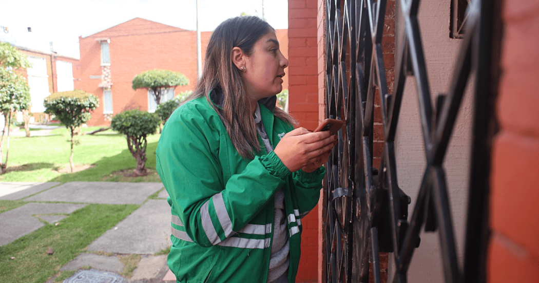 Funcionaria de la Secretaría Distrital de Ambiente realiza visita puerta a puerta en conjunto residencial del barrio Venecia para recopilar información de la comunidad durante jornada de atención ambiental.