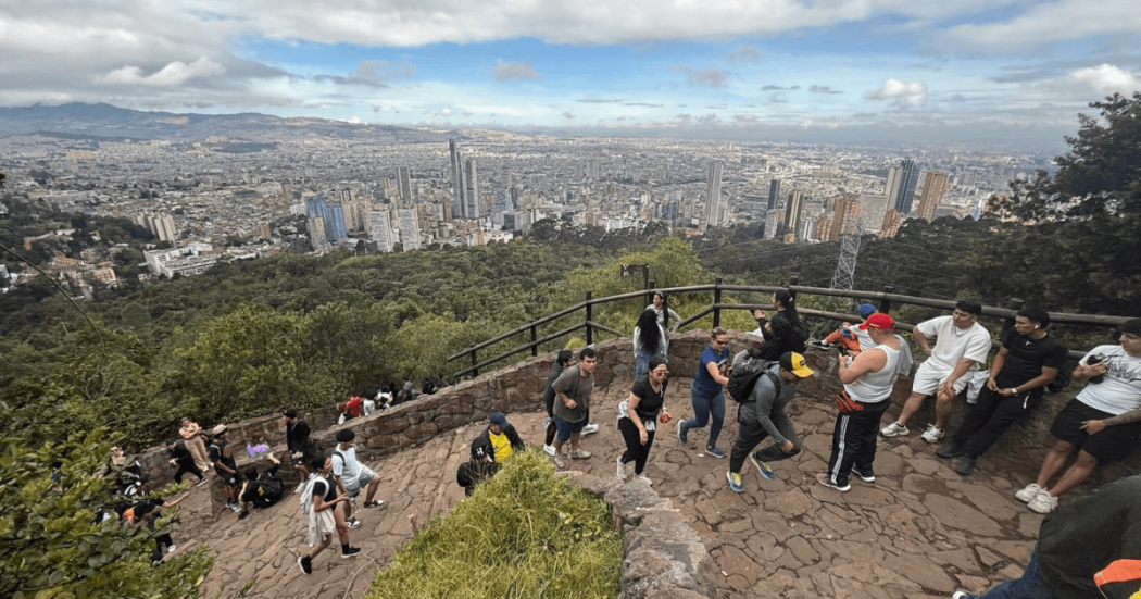 Personas recorren el sendero de Monserrate en Bogotá y descansan en mirador panorámico con vista al centro de la ciudad