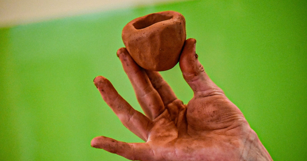 Foto de una mano haciendo una figura con arcilla