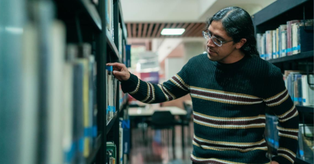 Foto de una persona buscando un libro