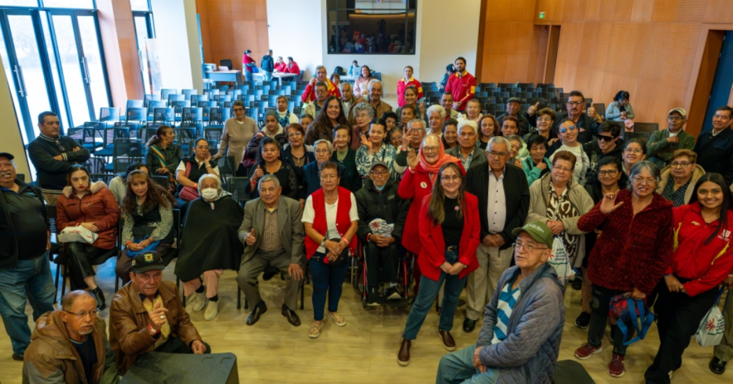 Foto de un grupo de adultos mayores en un auditorio 