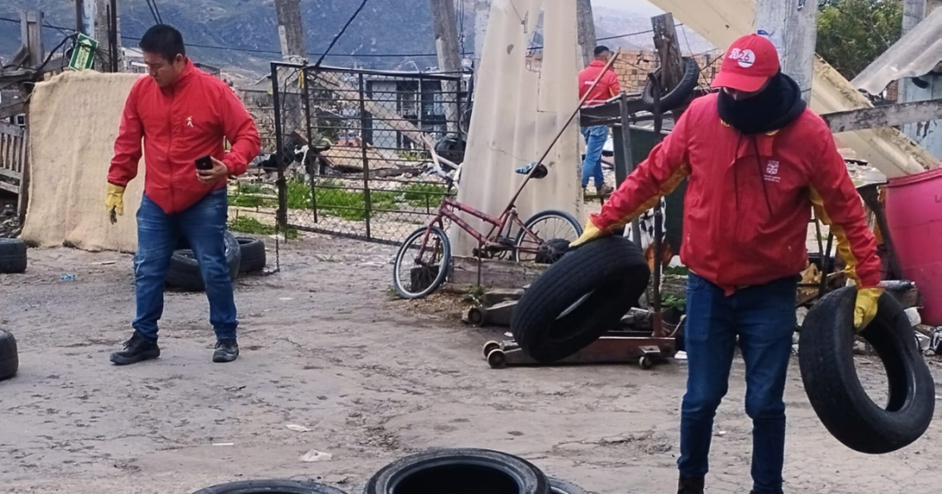 Imagen de dos funcionarios recogiendo llantas en la localidad de Usme