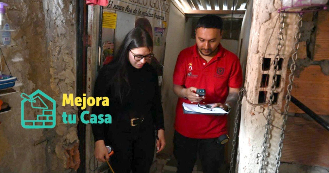 Foto que muestra dos personas una con un metro midiendo y la otra con un cuaderno tomando apuntes