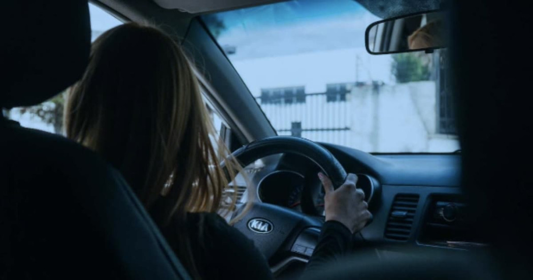 Foto de una mujer conduciendo un vehículo en una vía de Bogotá.
