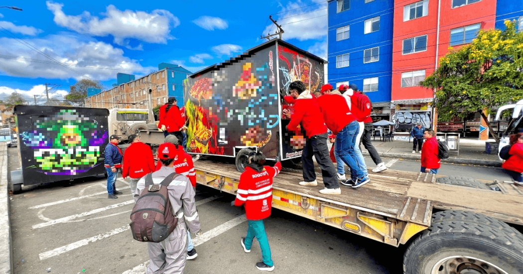 Foto que muestra un grupo de personas empujando un trailer de comidas