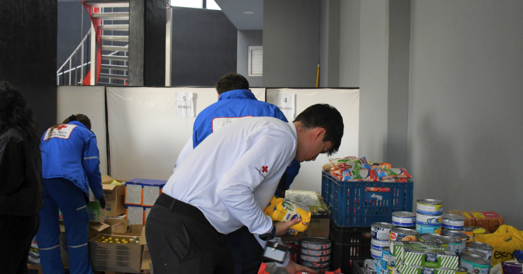 oto que muestra personas de la Cruz Roja organizando alimentos e insumos