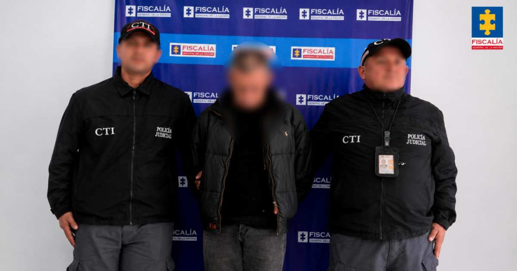 Foto que muestra un capturados y dos personas con uniforme de la Fiscalía 