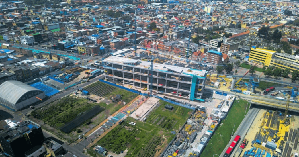 Foto que muestra un edificio en construcción y árboles 