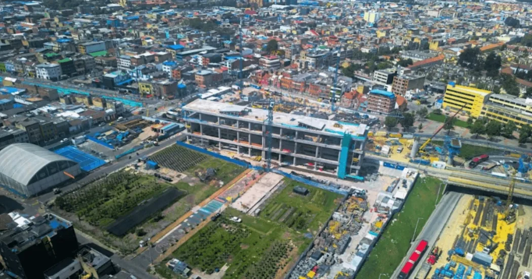 Foto que muestra un edificio en construcción y árboles 