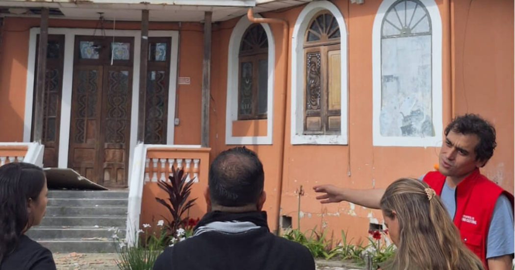 Imagen del director del IDPC con personas al frente de una casa para remodelar