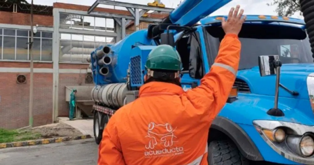Foto que muestra una persona con el uniforme de Acueducto de Bogotá levantando la mano