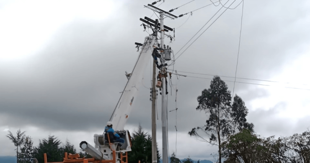 Foto que muestra personas con el uniforme de Enel Colombia trabajando en un poste de luz