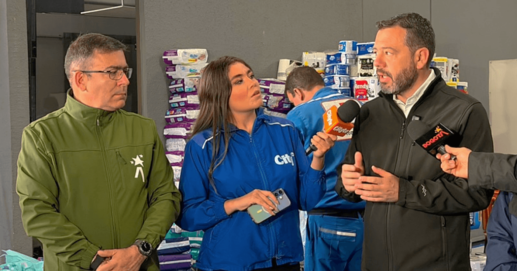 Alcalde de Bogotá, Carlos Fernando Galán y el director del IDIGER, Guillermo Escobar, dan declaraciones a medios de comunicación en un centro de acopio con insumos de ayuda humanitaria apilados al fondo para atender a personas afectadas por sismo del lunes 10 de agosto