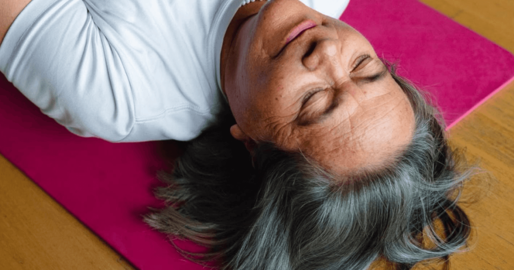 Mujer indígena con los ojos cerrados, acostada sobre el piso boca arriba.