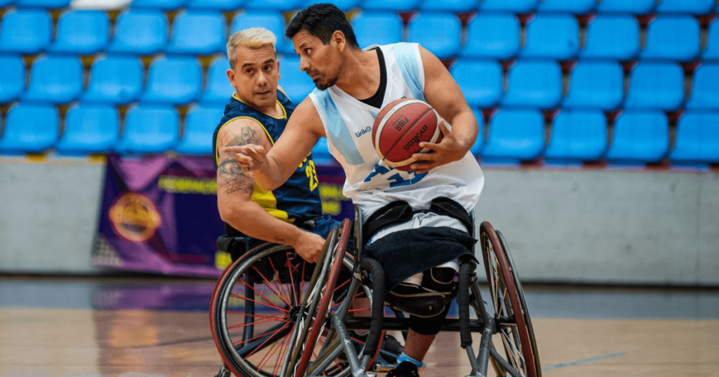 paradeportistas compiten en un partido de baloncesto en silla de ruedas dentro de un coliseo de Bogotá.