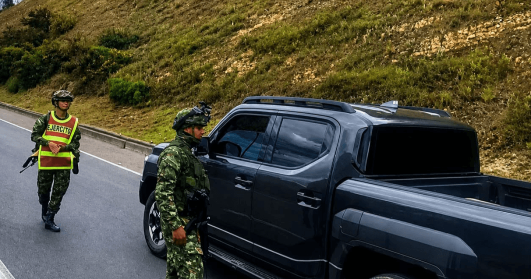 Uniformados del Ejército acercándose a una camioneta negra en una carretera.
