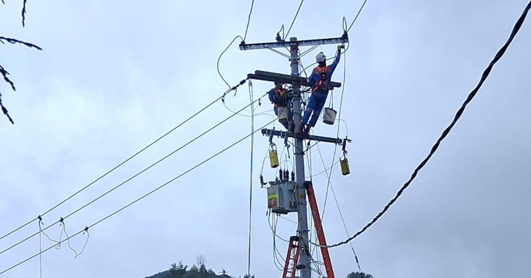 Foto que muestra dos personas con el uniforme de Enel Colombia trabajando en una antena de energía