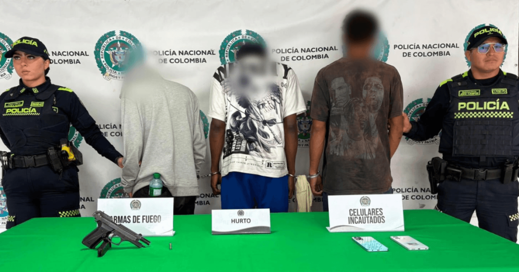 Tres hombres capturados, en medio de dos policías.