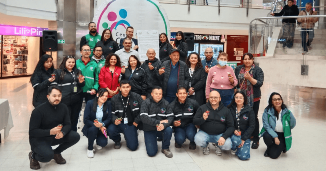 Grupo de personas reunidas en el interior del centro comercial Ciudad Tunal durante la firma de un compromiso para el cuidado de las coberturas vegetales de Bogotá.