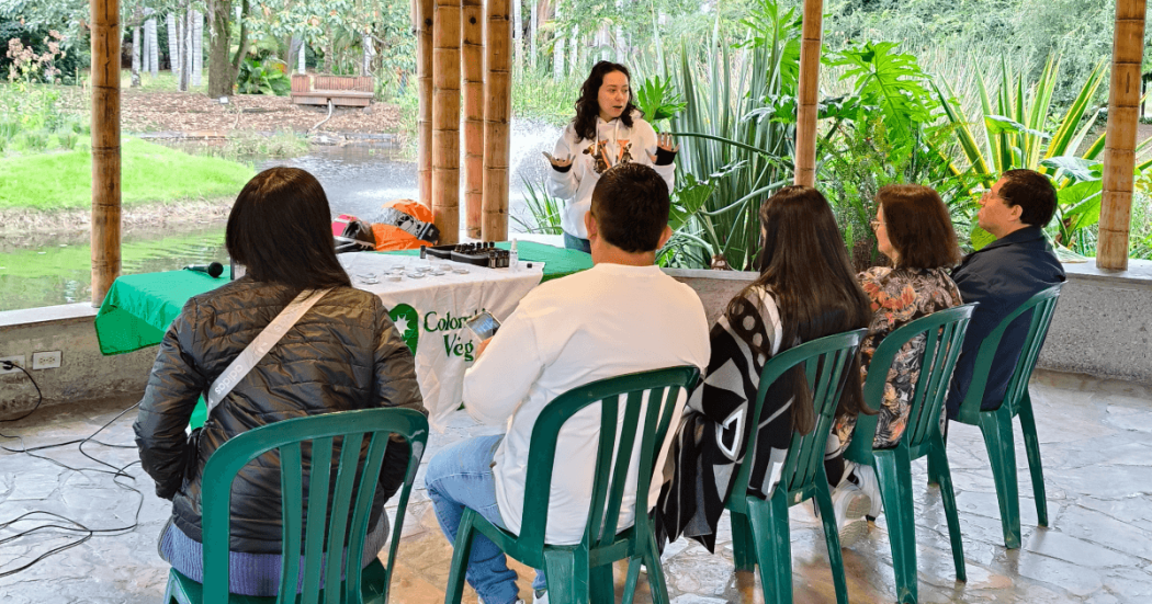 personas sentadas en sillas dentro del Aula Ambiental del Jardín Botánico de Bogotá participan en charla Cada Gota Cuenta a cargo de Colombia Veg.