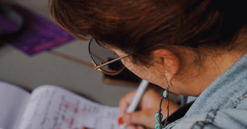 Mujer escribiendo en un papel.