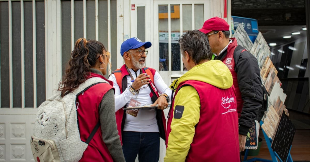 Funcionarios de la Secretaría de Planeación conversando con un ciudadano 