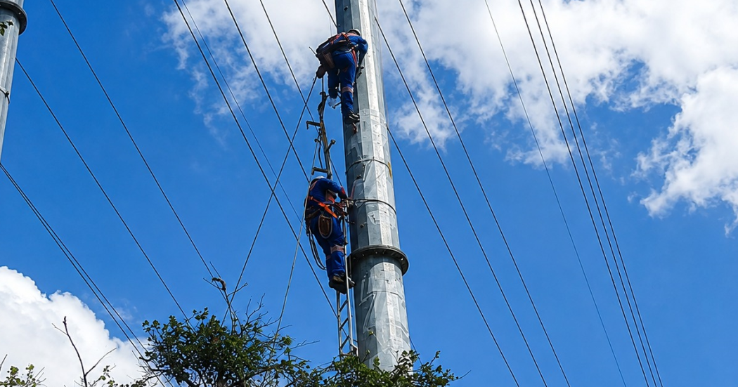 Foto que muestra a un operario de la empresa de energía haciendo una reparación en un poste de luz.