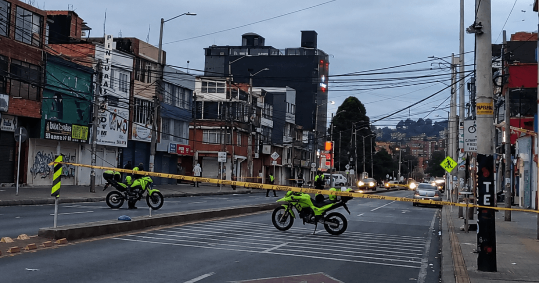 Vía principal de Bogotá cerrada por autoridades de tránsito con cinta de seguridad y motocicletas oficiales.
