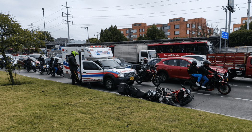 Ambulancia detenida sobre una vía de Bogotá junto a dos motocicletas caídas en el carril.