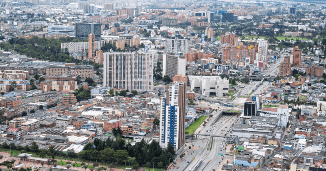 Vista aérea de Bogotá con edificios residenciales y comerciales, corredores viales de alta circulación y amplias zonas urbanas.