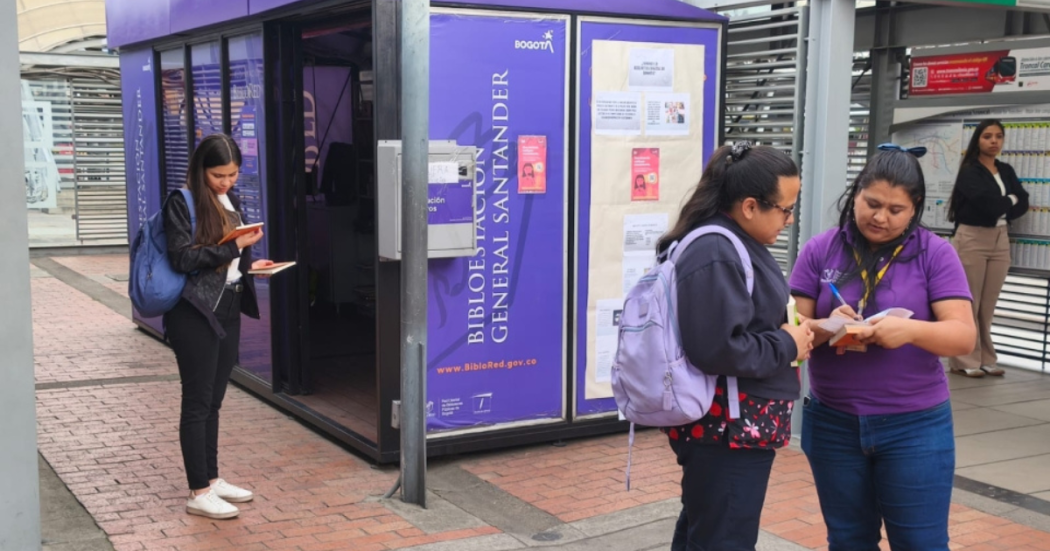 Imagen de personas leyendo libros en una estación de Transmilenio en Bogotá.