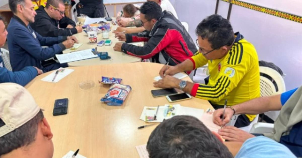 Hombres reunidos en una mesa abordando temas como el reconocimiento de emociones