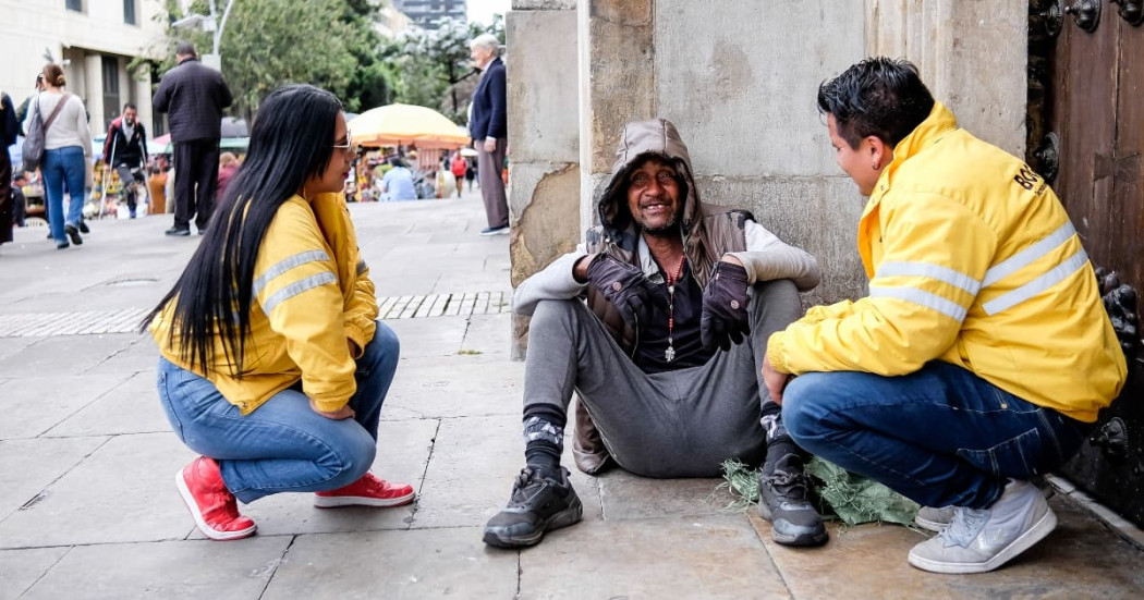 Dos funcionarios de la Secretaría de Integración Social conversando con un habitante de calle. 