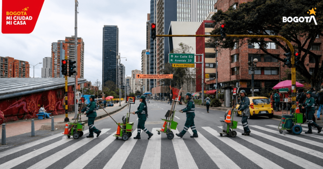 Foto que muestra operarios de aseo cruzando una calle.