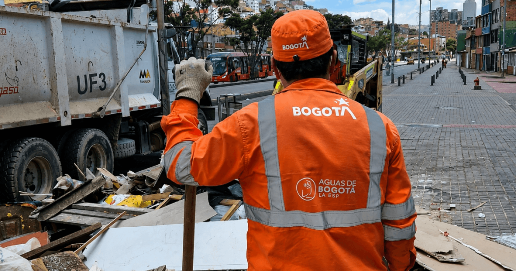 Foto que muestra una persona con el uniforme de Aguas de Bogotá en una calle con residuos