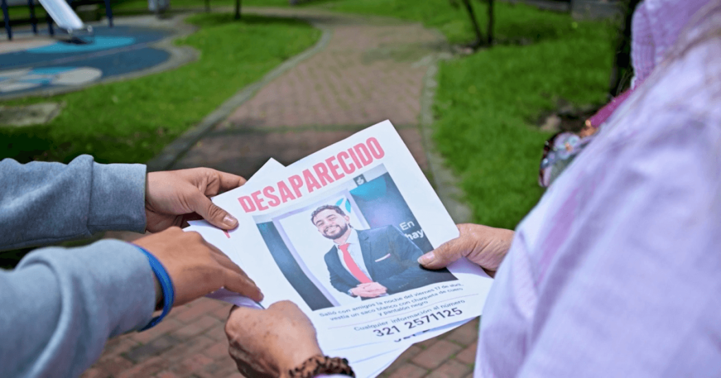 Personas sosteniendo un cartel de persona desaparecida. 