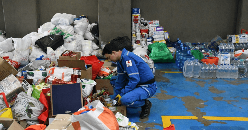 Foto que muestra una persona organizando elementos como alimentos, papel higienico y cajas