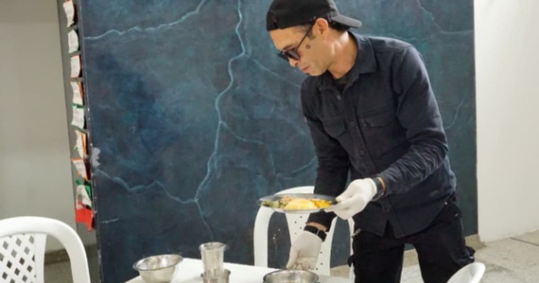 Un hombre recogiendo unos platos en un comedor comunitario de Bogotá