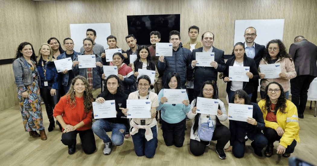 Foto que muestra un grupo de personas sonriendo con diplomas en las manos