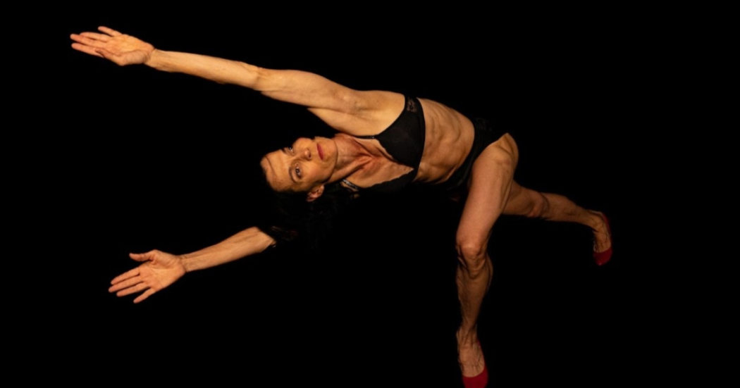 Imagen de una mujer vestida de negro en posición de danza.