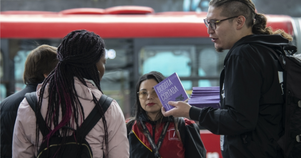 Imagen de varios jóvenes recibiendo ejemplares gratuitas de Libro al Viento en TransMilenio.