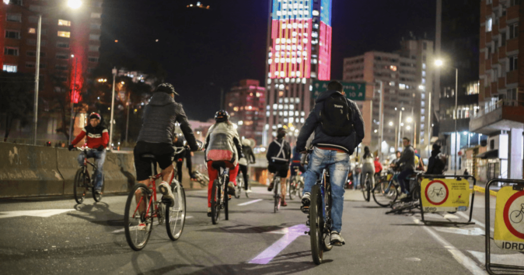 Ciudadanos montando bicicleta en la noche.