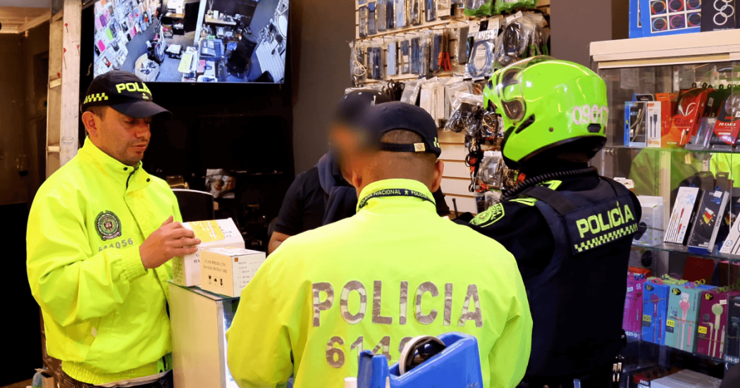 Policías inspeccionando establecimiento de venta de celulares.