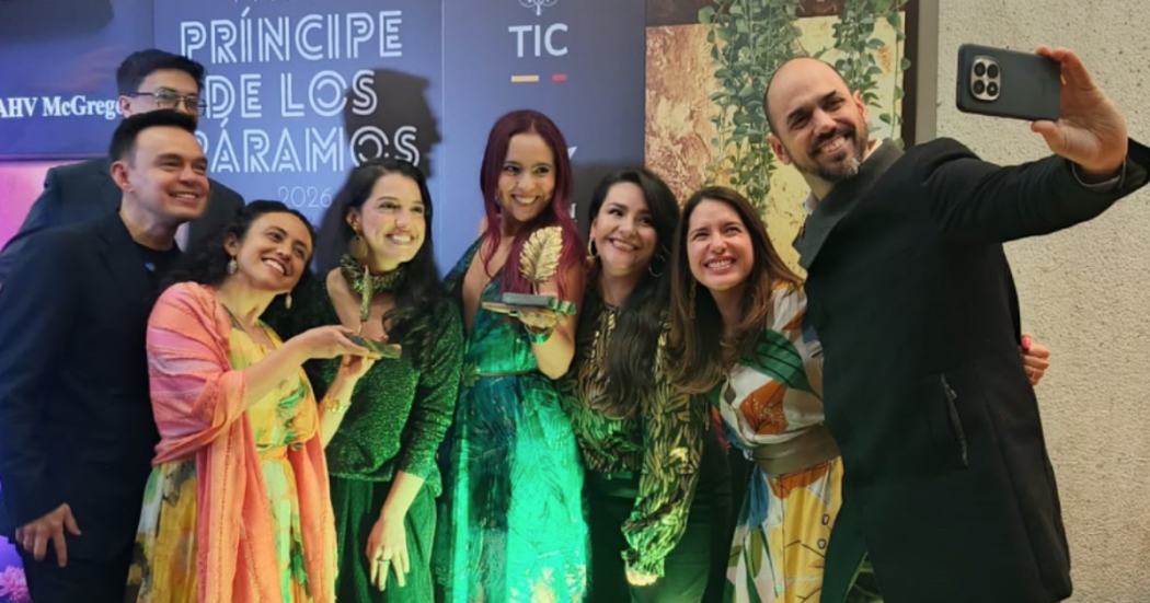 Imagen del equipo de la serie acompañando a Sara quien carga el premio en sus manos.